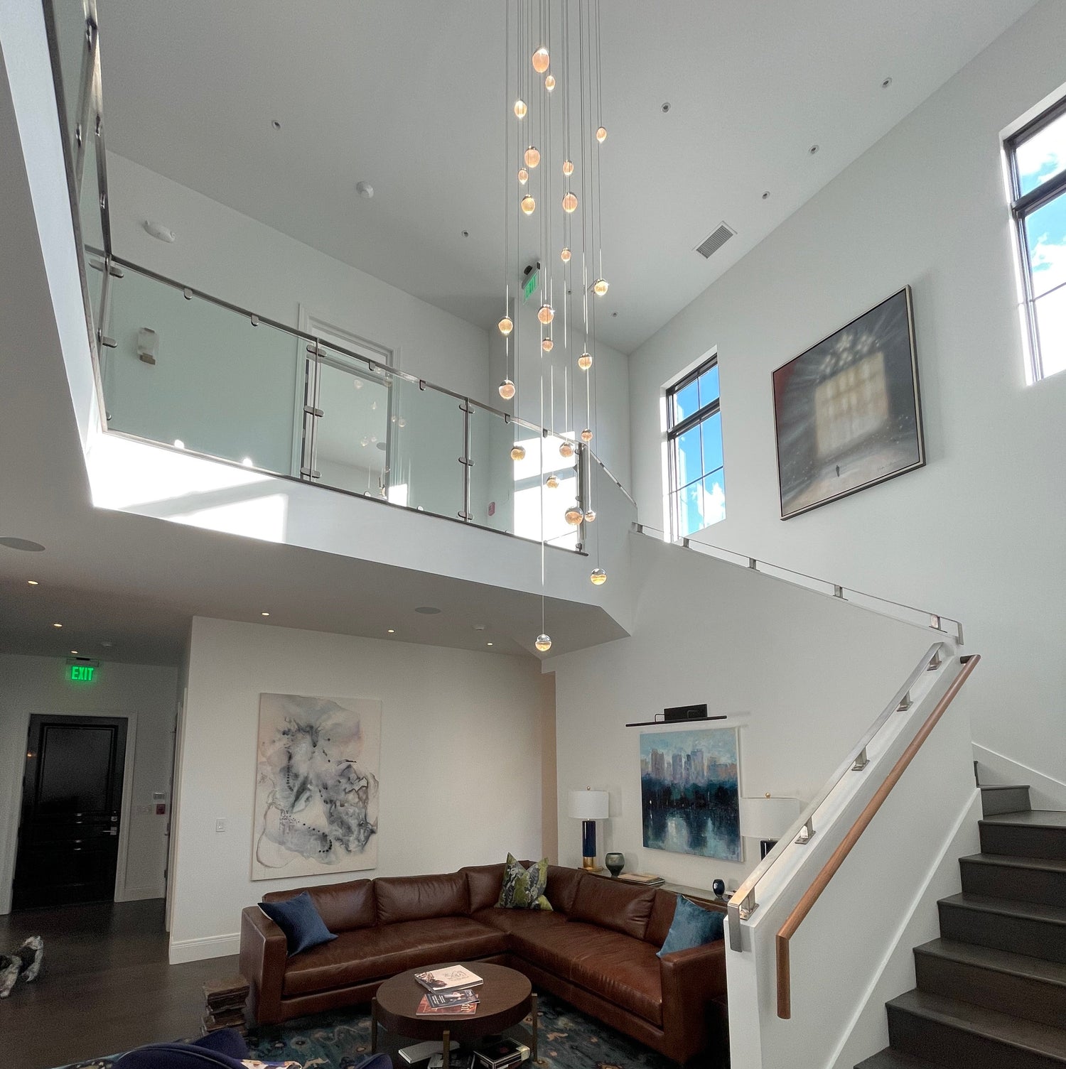Modern living room with a staircase, sectional sofa, and decorative elements.